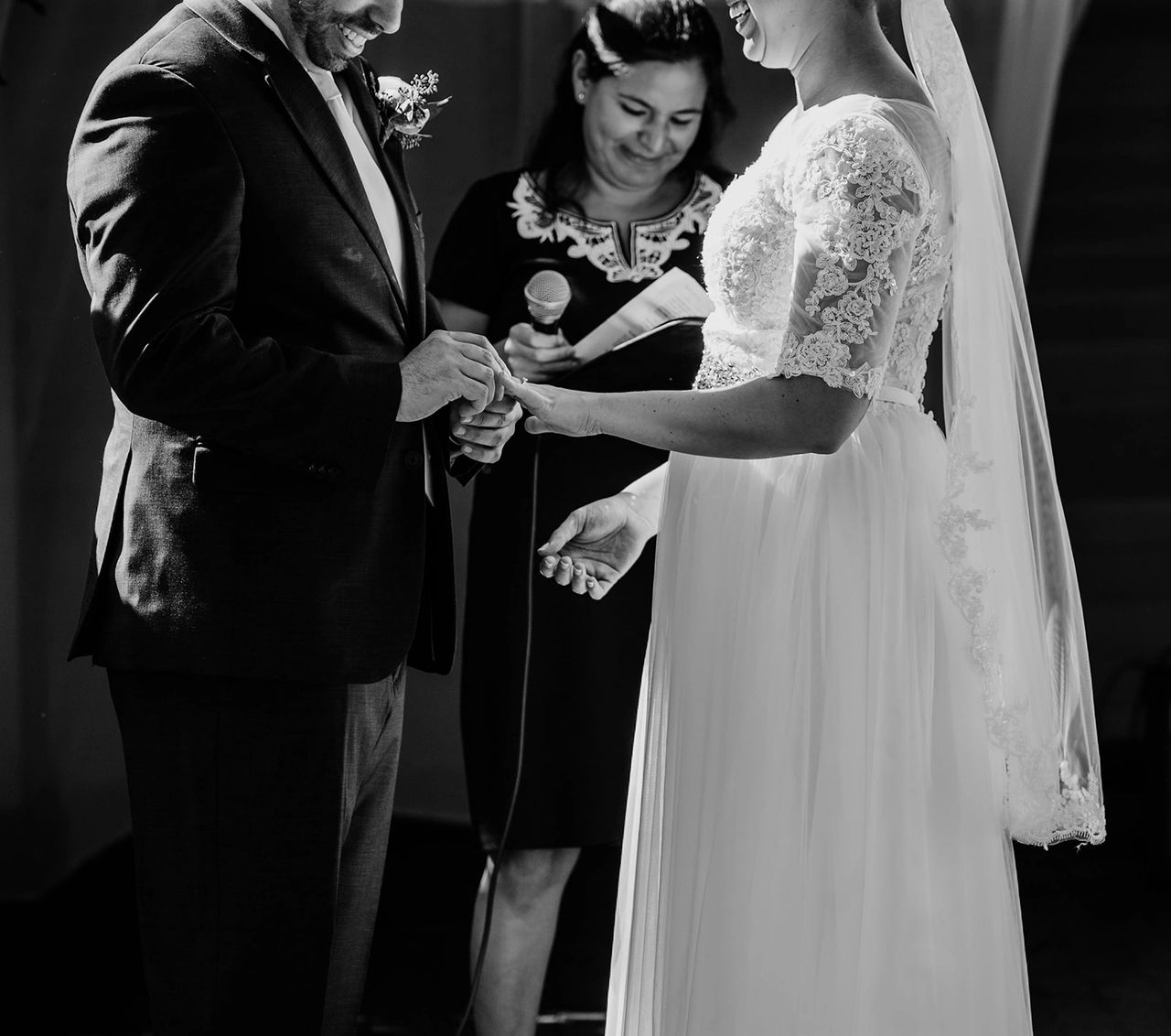 Groom sliding ring onto bride's hand