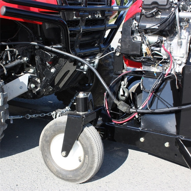 A front-oblique view of the Kawasaki Mule/Teryx snowblower by Bercomac, focusing on the wheel, installed and parked in a lot.