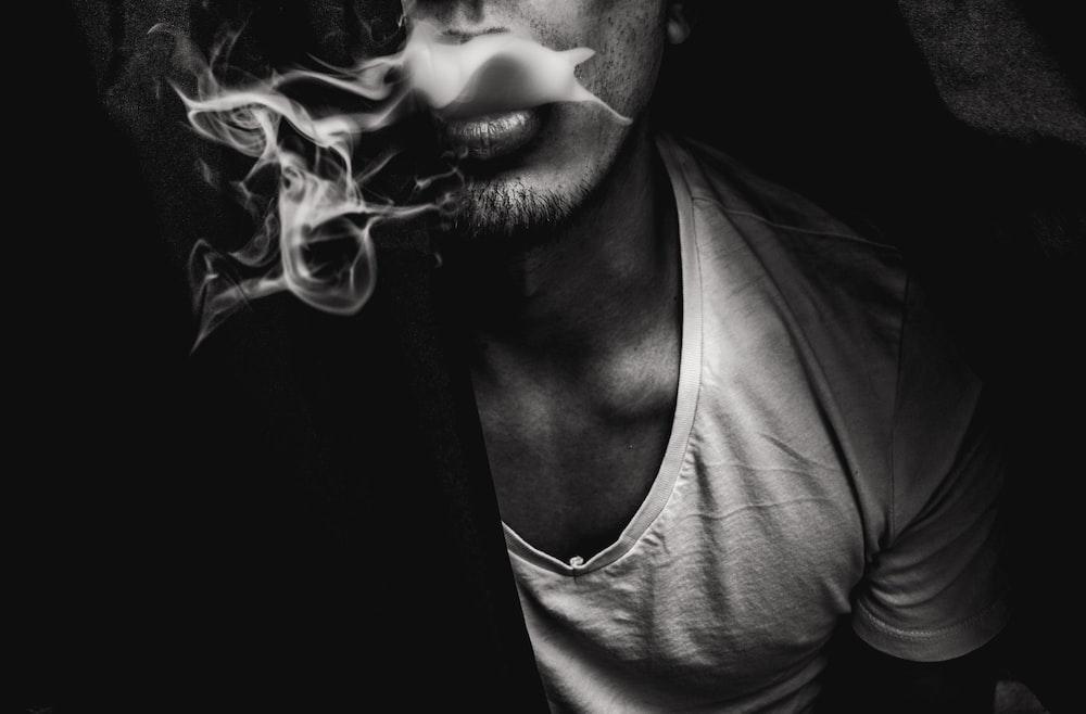 man wearing white V-neck shirt with smoke coming out of mouth