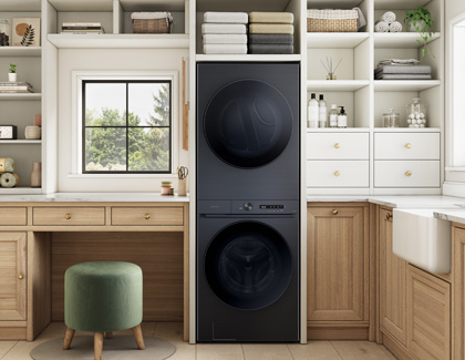 A Samsung bespoke washer and dryer set stacked on top of each other in a wooden storage shelf.