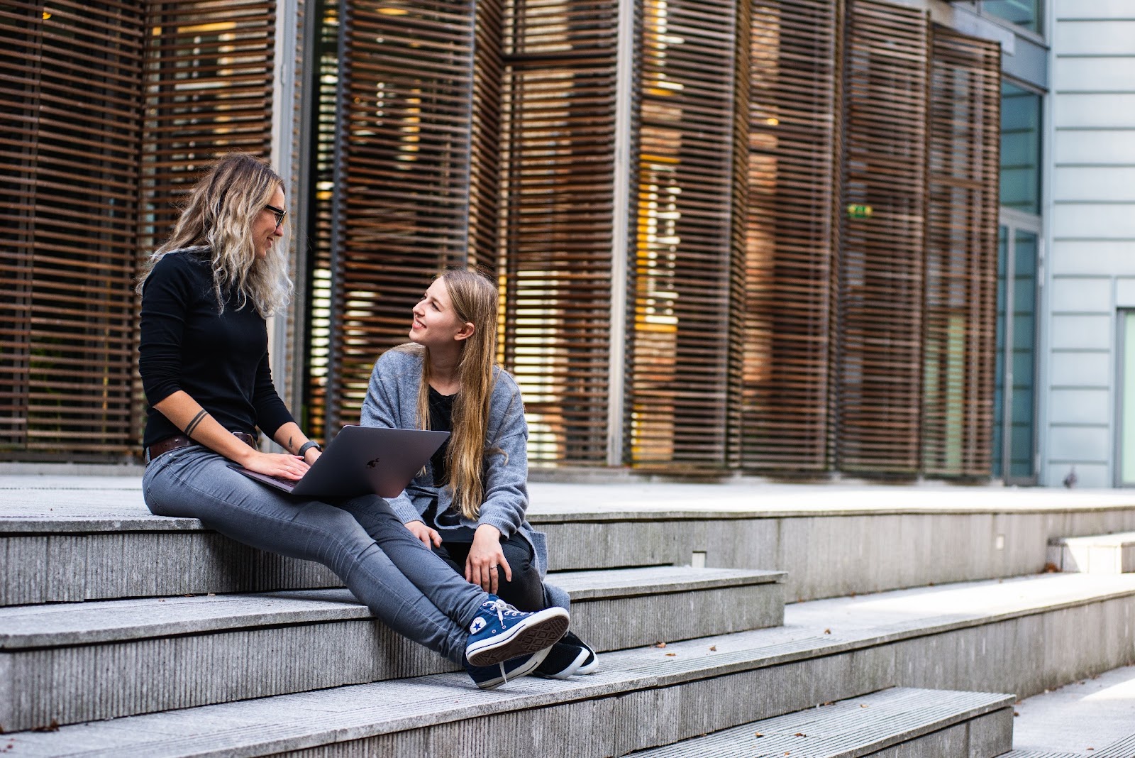 Two women meeting outside of a building