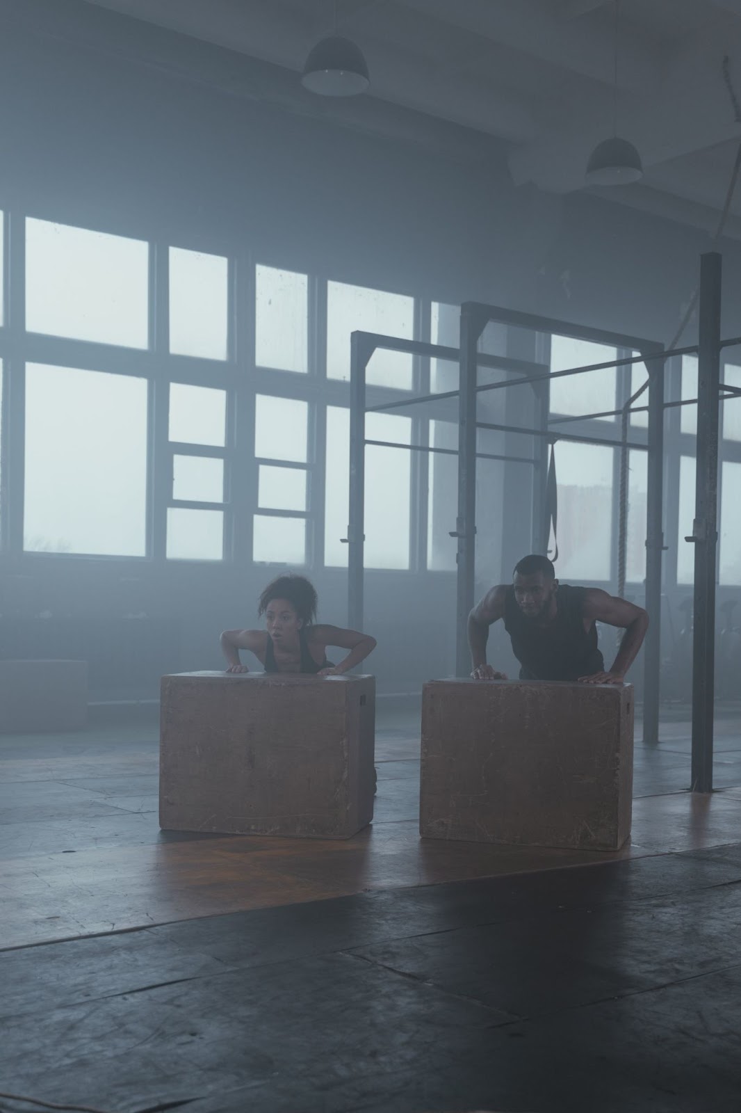 Two people doing angled push-ups on wooden boxes