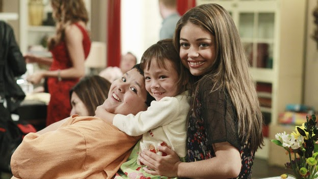 Photo of Manny, Lily and Haley hugging together on the couch. One of the best holiday tv episodes!