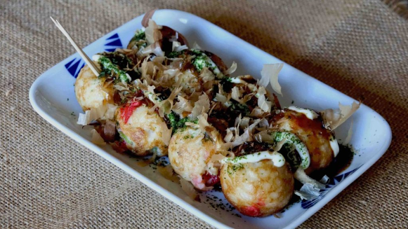 Takoyaki: These are delicious ball-shaped snacks made of a wheat flour-based batter and cooked with minced octopus. Takoyaki is a popular street food, often topped with takoyaki sauce, mayonnaise, and dried bonito flakes.