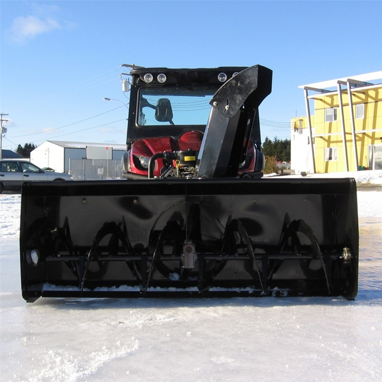 A picture facing the front end of a UTV parked on icy terrain with a Bercomac John Deere Gator XUV Snowblower installed