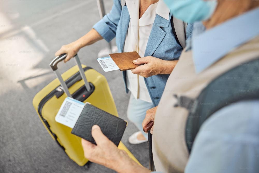 Cropped photo of a man in a face mask and a Caucasian woman standing at the airport