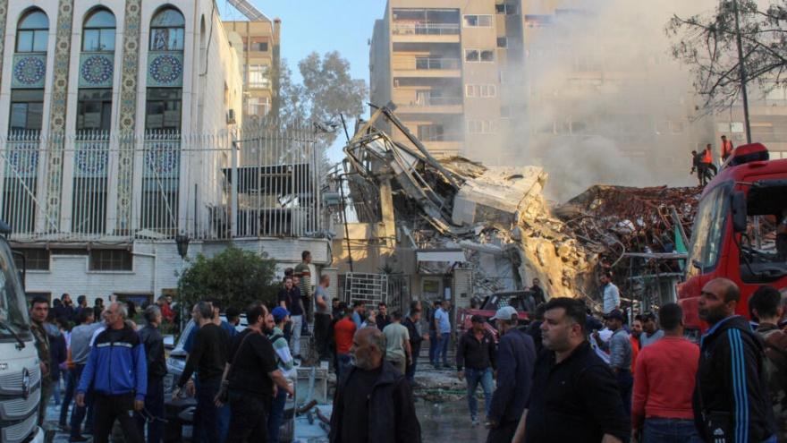 People gather near a damaged site after what Syrian and Iranian media described as an Israeli air strike on Iran's consulate in the Syrian capital Damascus April 1, 2024.