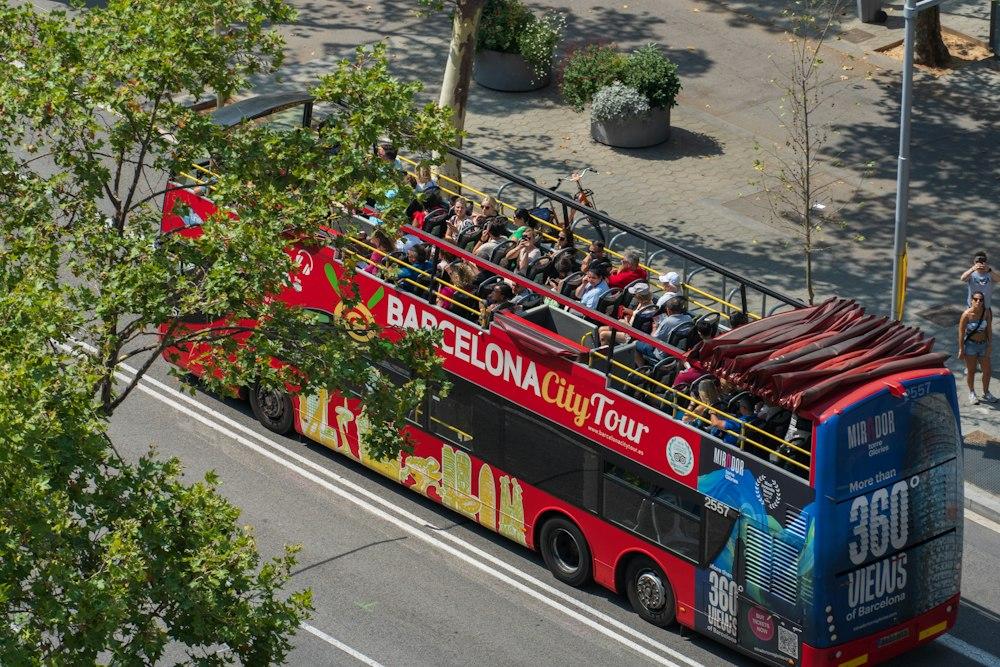 a double decker bus filled with people driving down a street