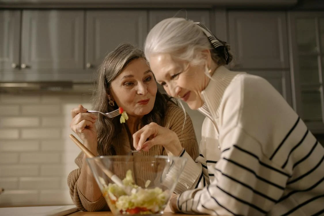 elderly women eating salad in the kitchen