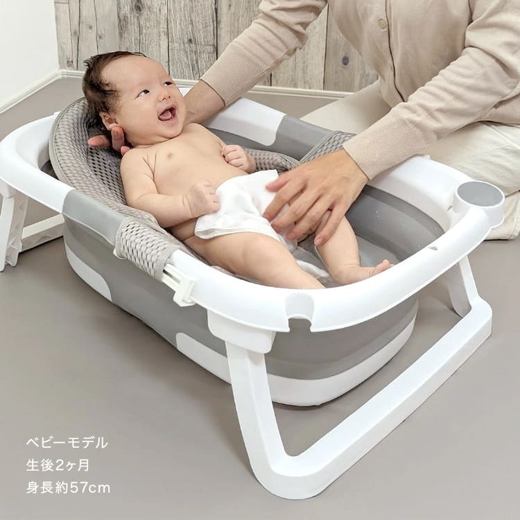プラスチックタイプの折りたたみ式ベビーバスで沐浴する赤ちゃん