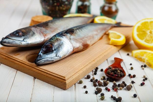 Raw mackerel on a cutting board with spices. cooking fish.