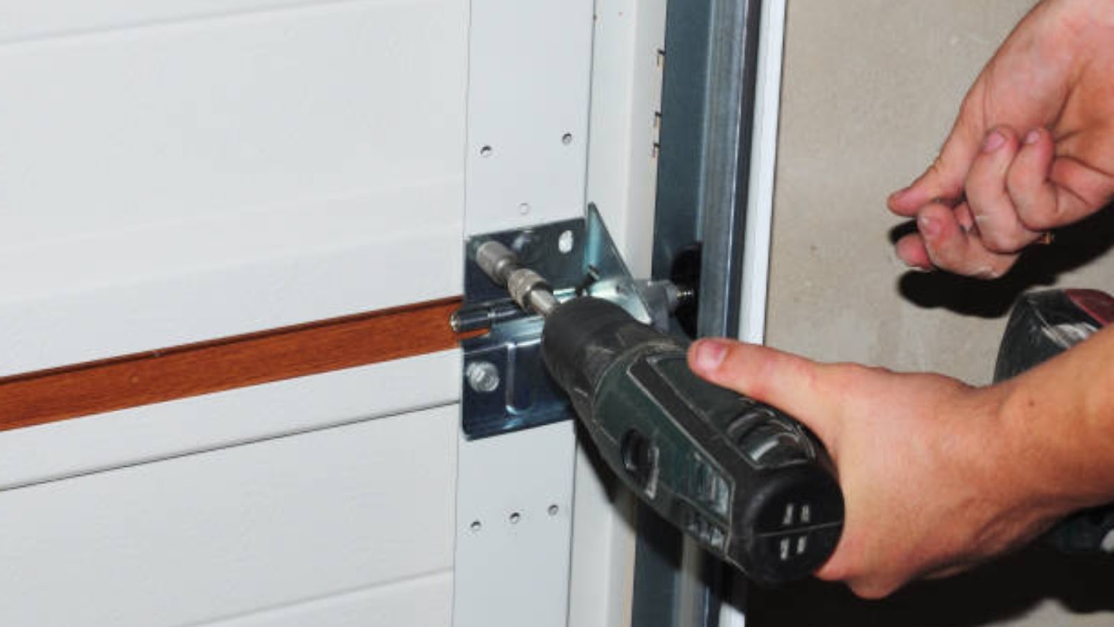 A technician adjusting all garage door hardware