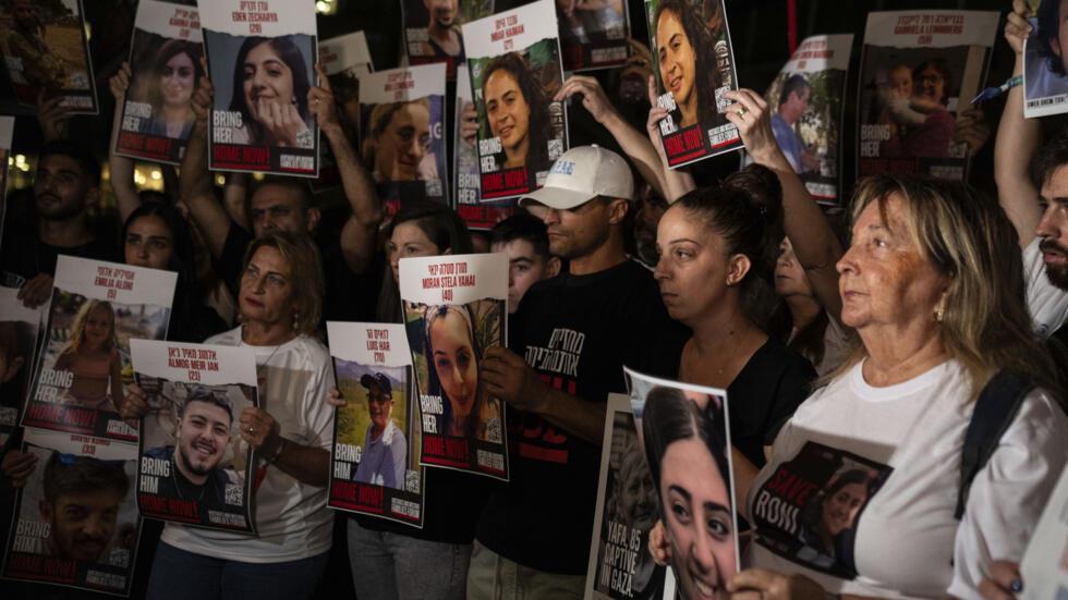 Des parents de personnes enleves par des membres du Hamas tiennent les photos de leurs proches lors d'une manifestation,  Tel Aviv, le samedi 21 octobre 2023.