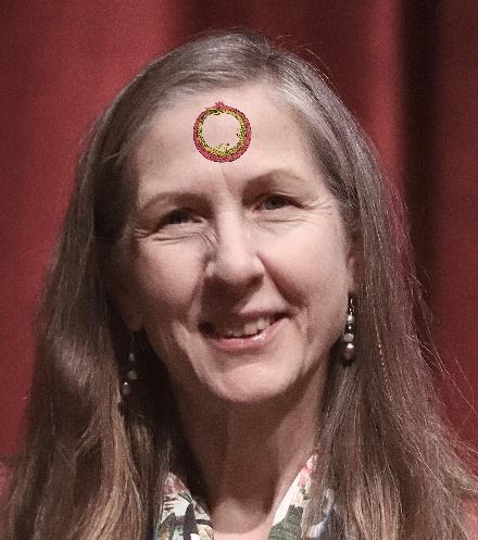 A person smiling with a circle on her forehead

Description automatically generated