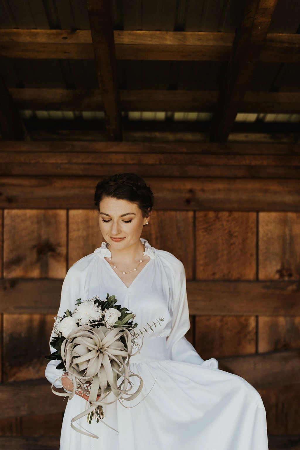 Bride holding bouquet and looking down at it
