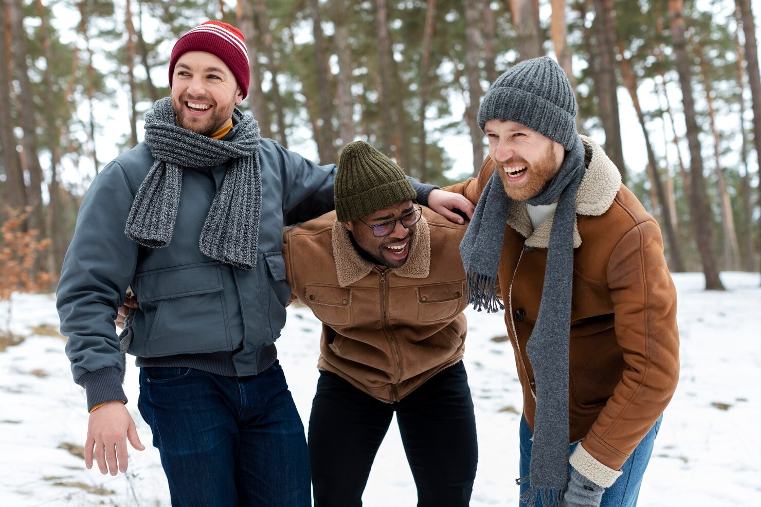 Three male friends enjoying a joyful moment together in the winter.

