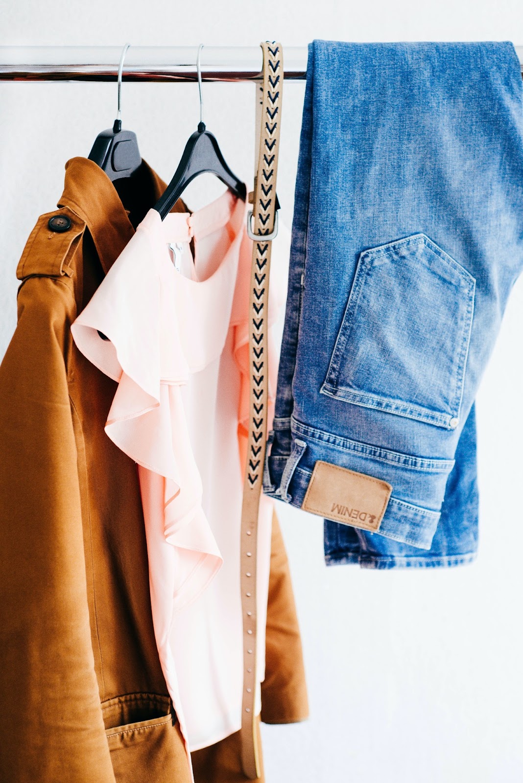 Versatile pieces of clothing hung on a rack to pack for travel. 