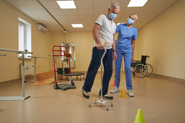An experienced occupational therapist guides a mature patient in motor skill rehabilitation at a medical center