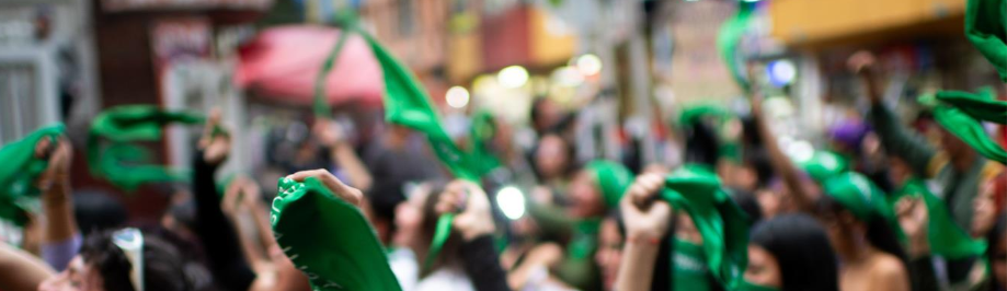 A group of people holding green flags Description automatically generated