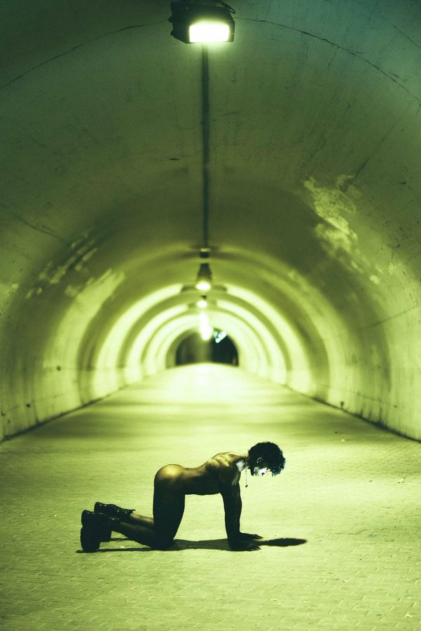 Jordan Jameson posing on his hands and knees naked in an empty traffic tunnel