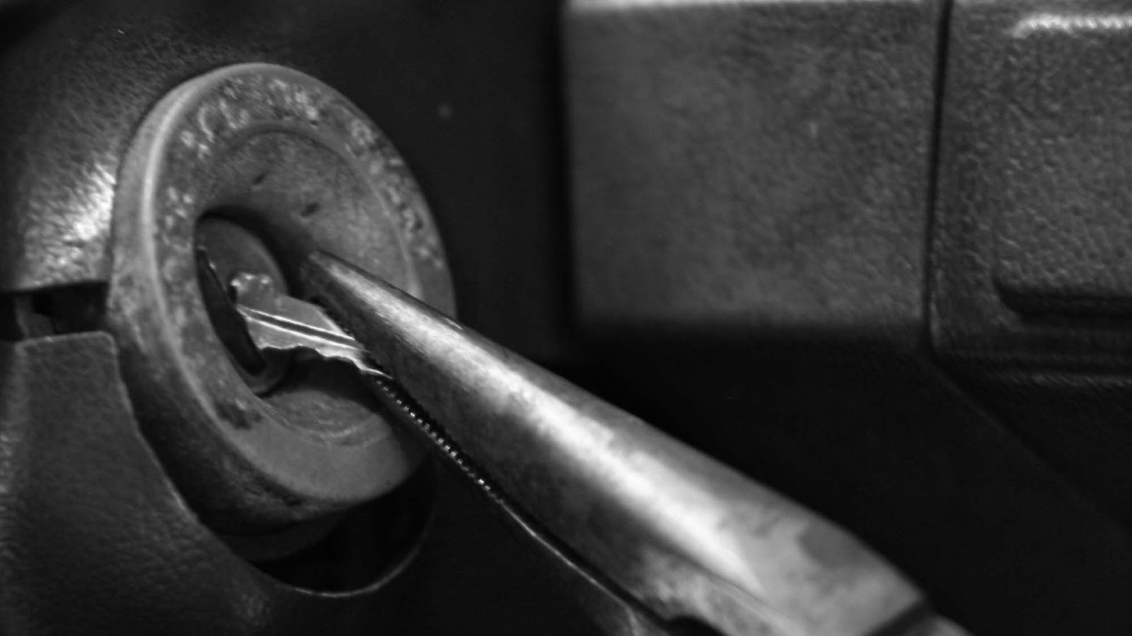 A locksmith pulling out a broken key piece during a broken key removal process