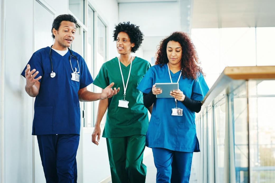 A group of medical professionals walking down a hallway Description automatically generated