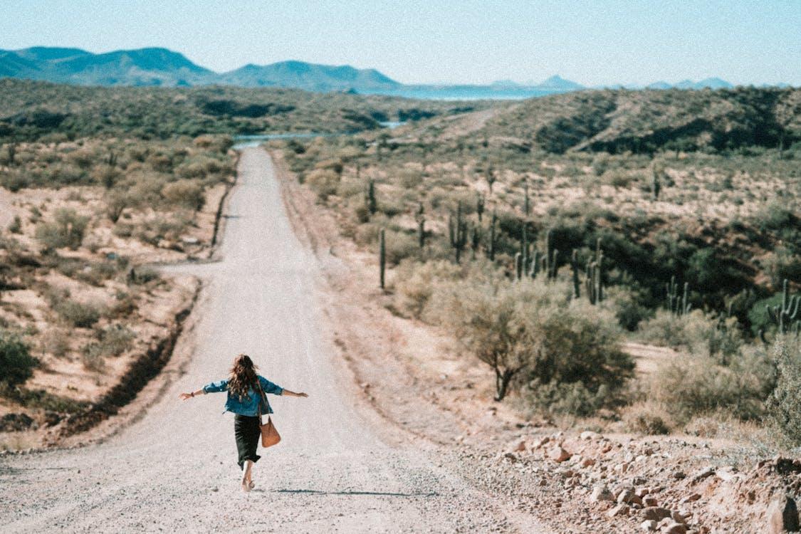 Free Woman Walking on Dirt Road Stock Photo