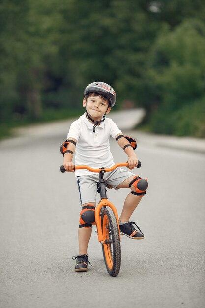 Child on a bicycle at asphalt road in summer. Bike in the park