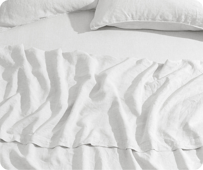 Our White Vintage Washed European Linen Fitted Sheet on a bed with coordinating flat sheet and pillowcases.