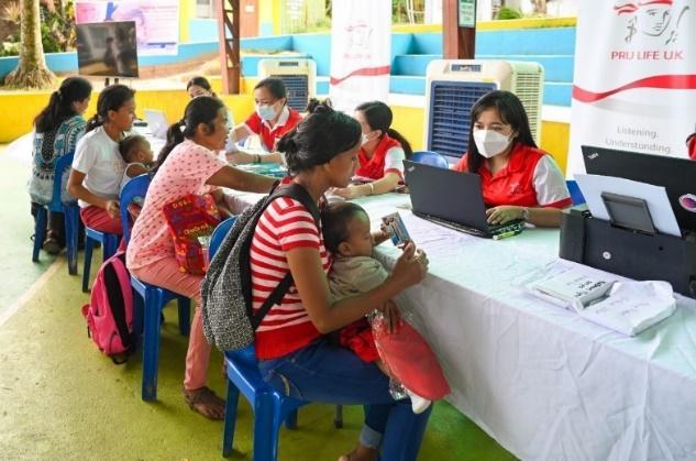 A group of people sitting at a table with a computer

Description automatically generated