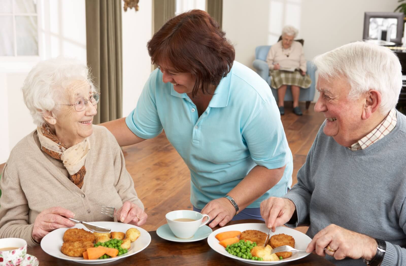 An older adult couple eating a delicious and healthy meal in a senior living community.
