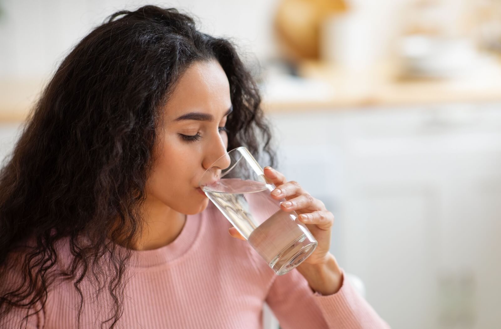 A woman drinking water from a glass.