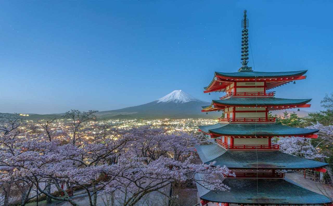 A traditional Japanese building with a view of Mount Fuji behind it.  