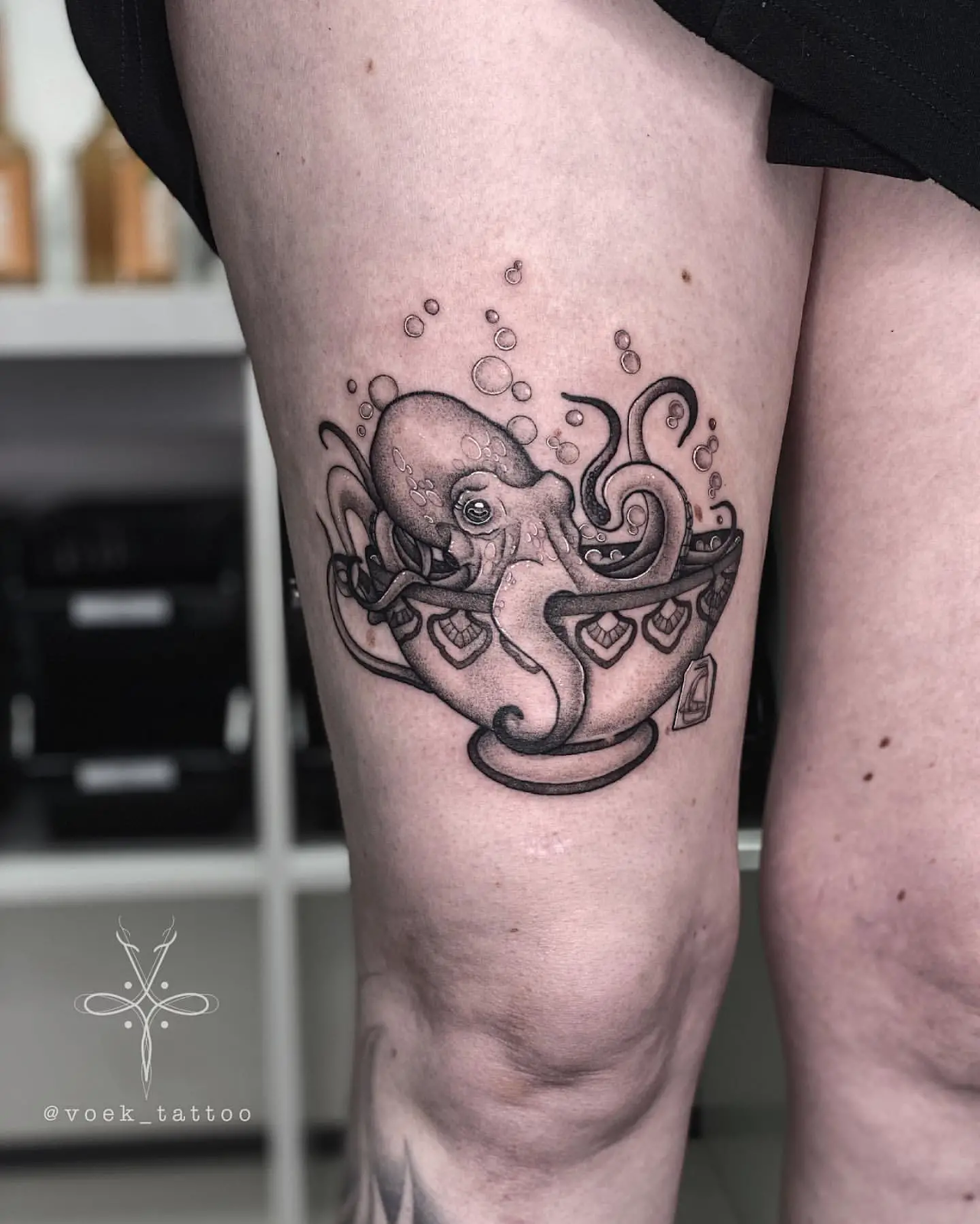 Picture showing a black and gray octopus tattoo design on a the thigh of a lady
