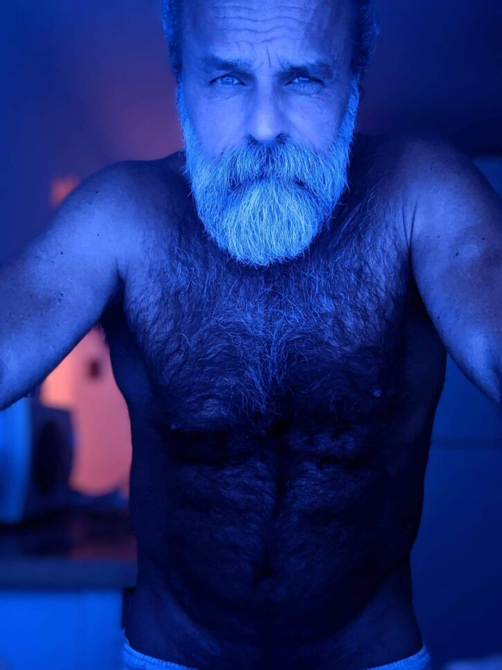 Daddy John sitting in the dark naked taking a webcam selfie