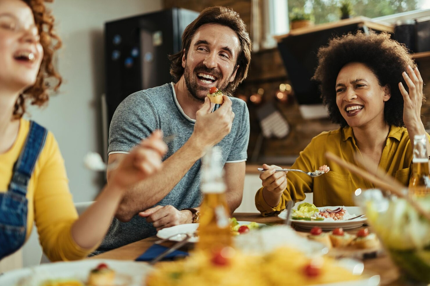 Friends sharing a joyful moment at a Friendsgiving table.