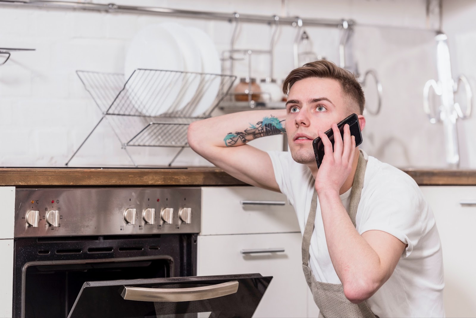 A person having stove problems, talking to professional stove repair services on the phone