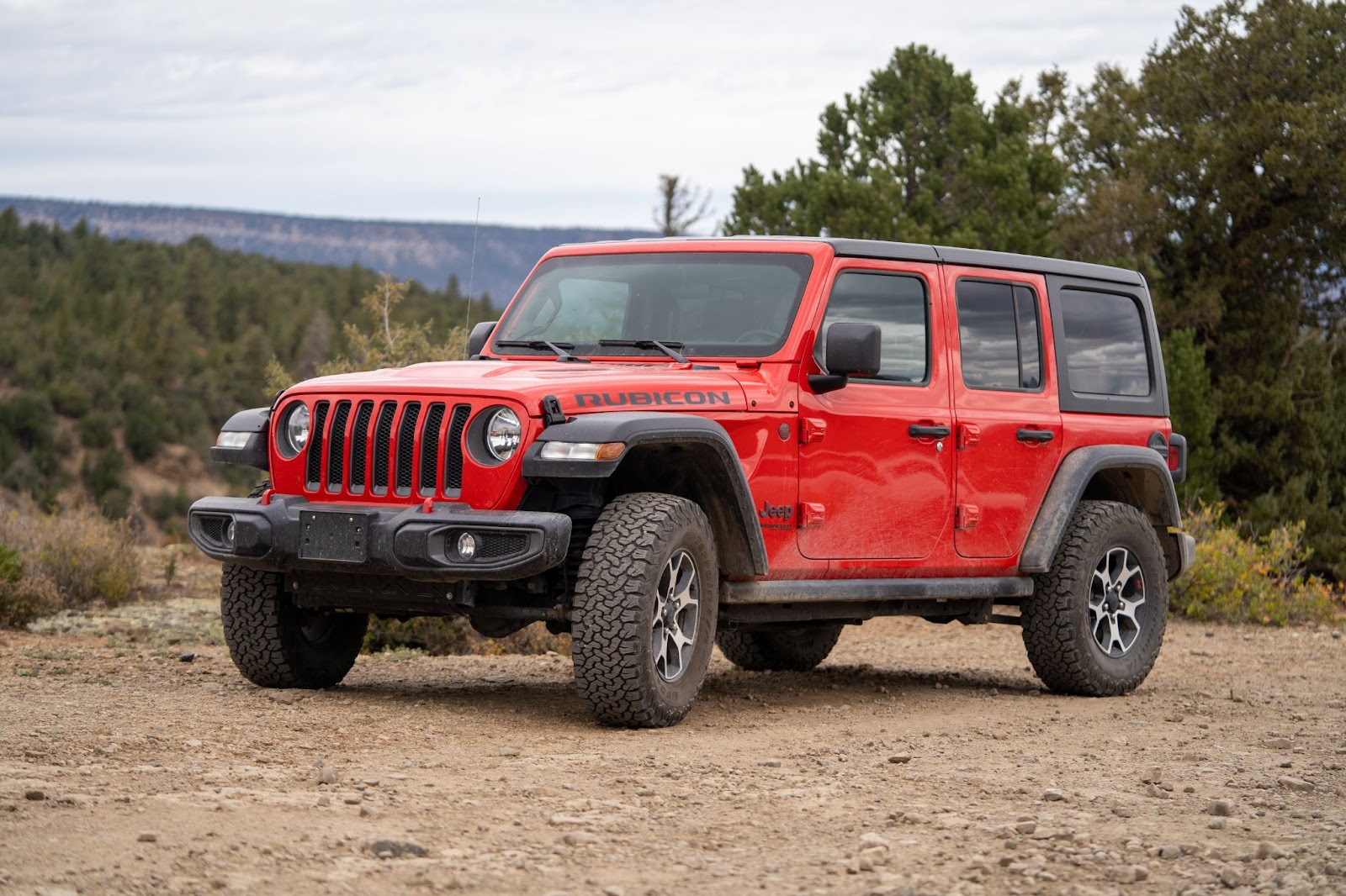 Red Jeep Wrangler Rubicon on top of a hill