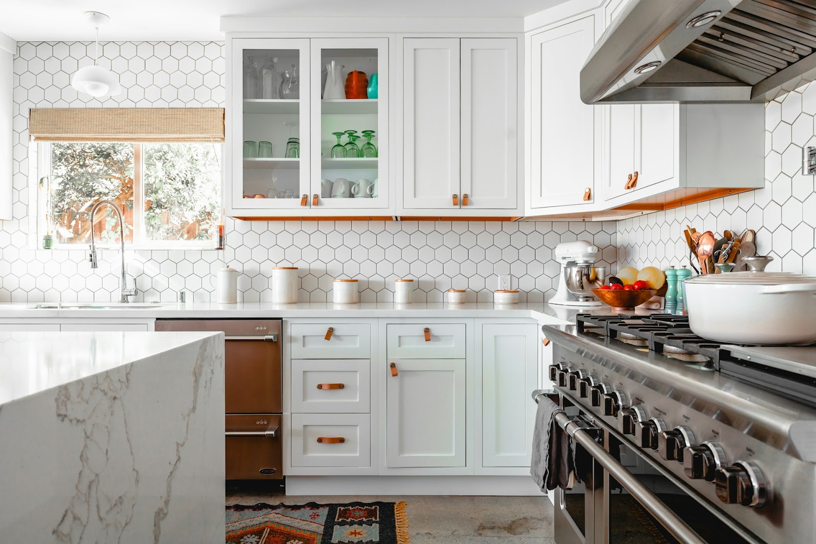 A minimalist-style kitchen with green cabinetry, wood floors, and sleek appliances