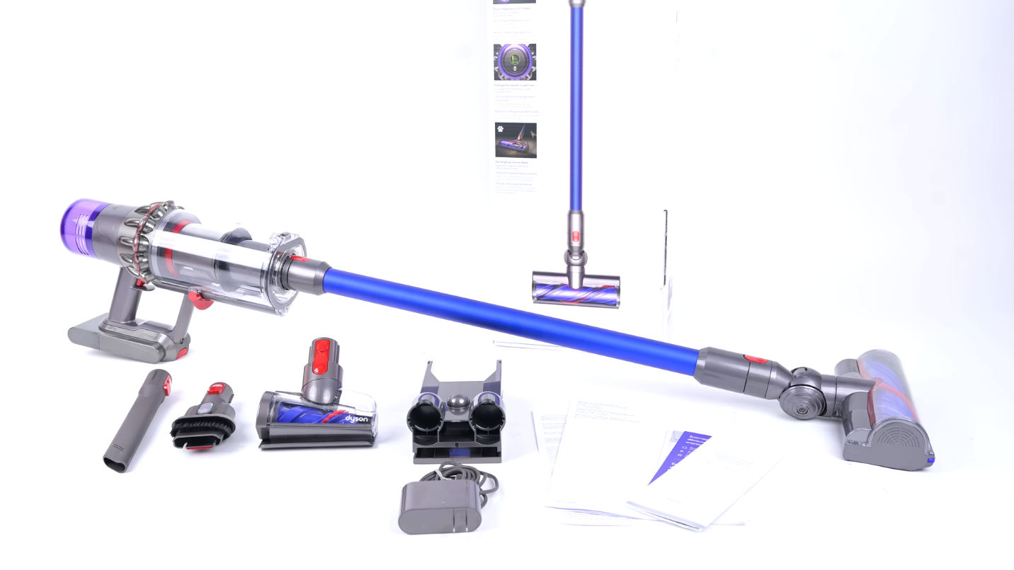 A complete set of the Dyson V11 cordless vacuum with a transparent dustbin, blue wand, motorhead, and various attachments against a white background — Dyson V11 cordless vacuum review by Vacuum Wars