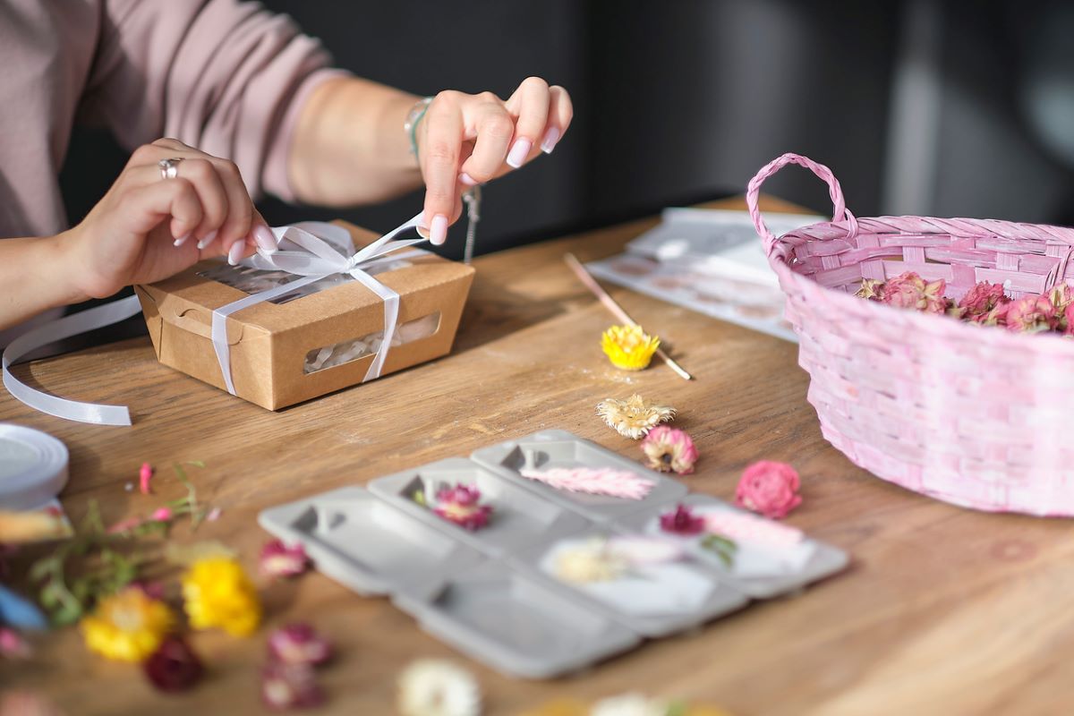  A woman packing a box with handmade candles.