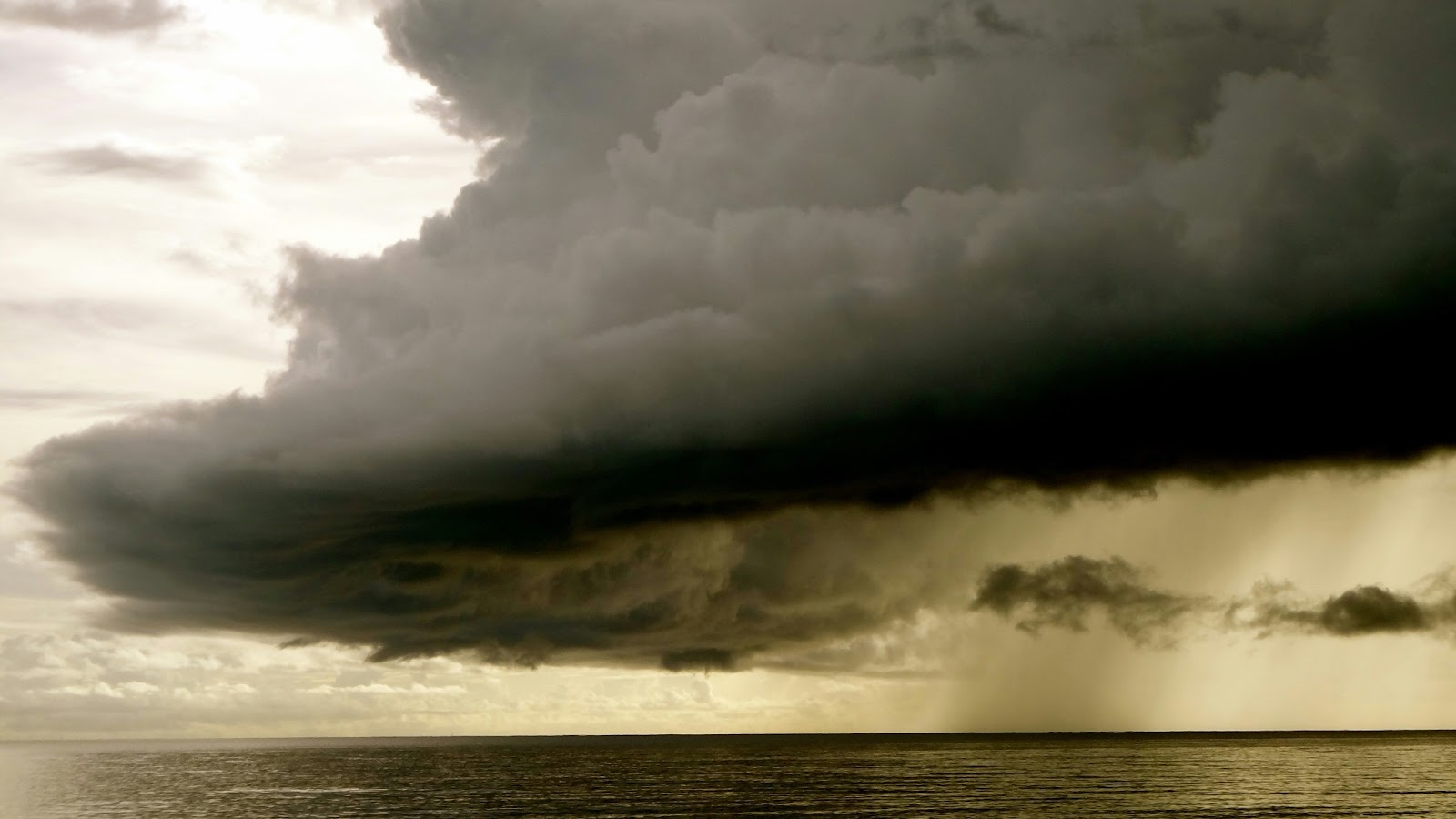 A dark cloud rolling over the beach during storm season. 