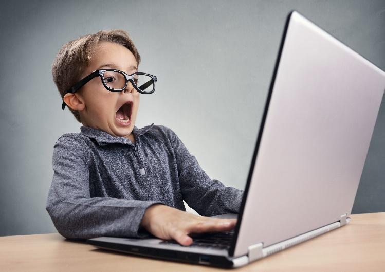 A young child with his mouth open and a computer