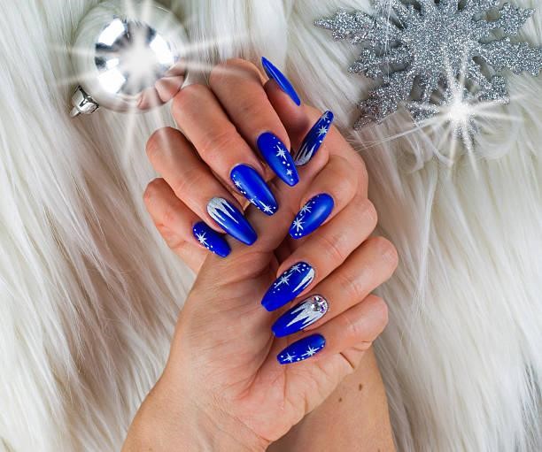 Christmas blue nails nails decorated with blue color and bright stars to celebrate Christmas and the last of the year Negative Space Galaxy Nails stock pictures, royalty-free photos & images