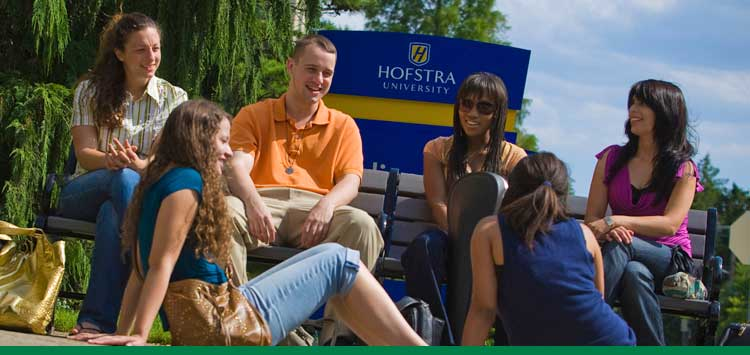 An image of a group of medical students from diverse backgrounds and ethnicities sitting together and smiling. 