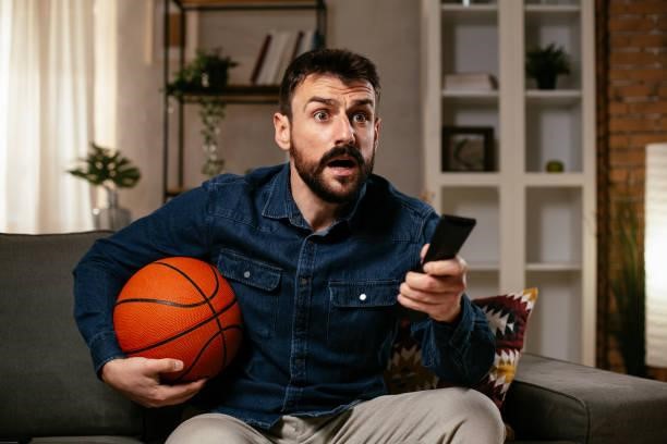 Man watching sports game on tv Happy man enjoying at home. Man watching sports game on tv Why Live Streaming NBA Games Is A Game-Changer For Fans stock pictures, royalty-free photos & images