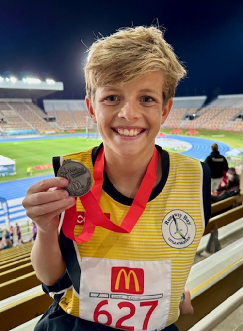 A child holding a medal

Description automatically generated