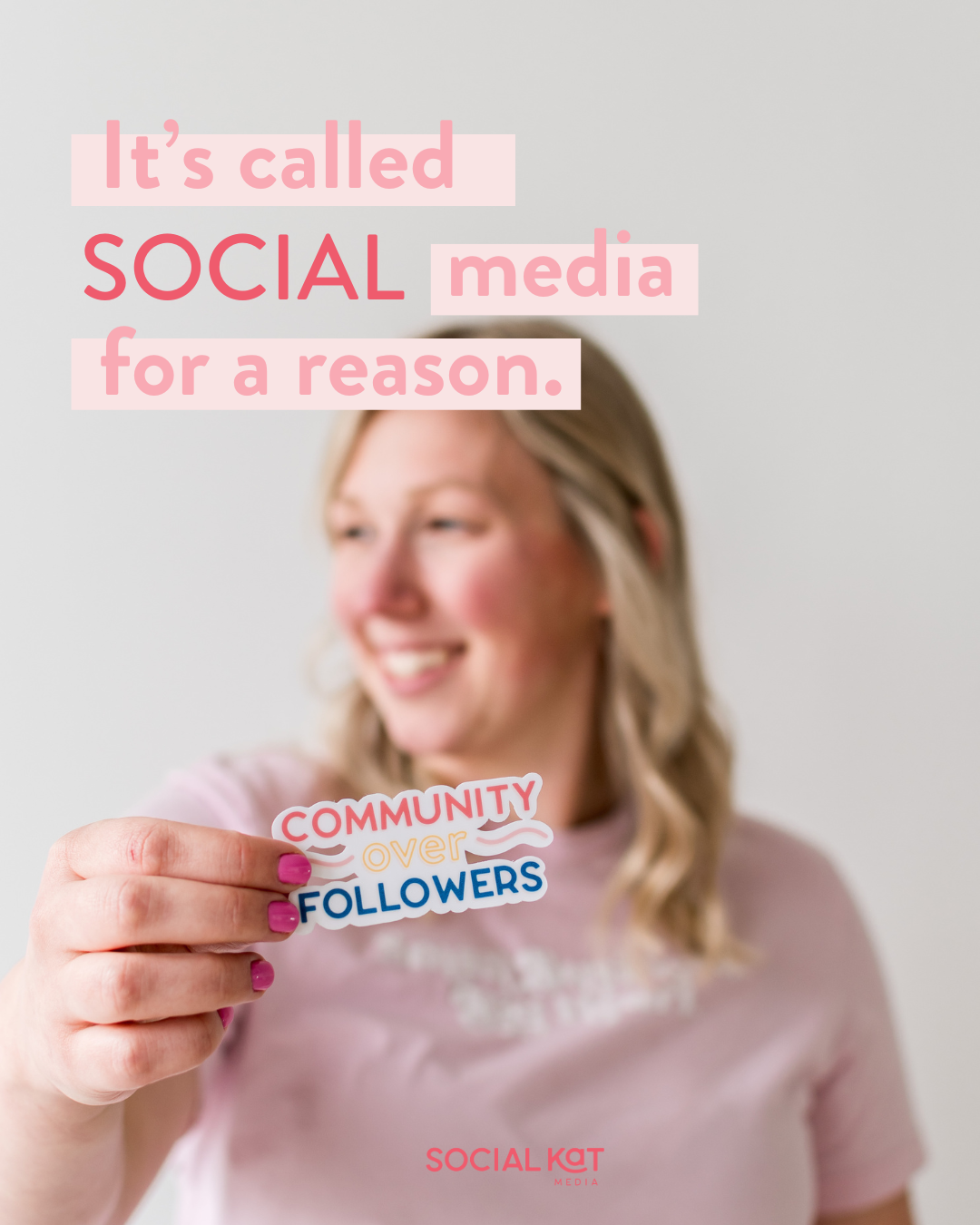 It's called SOCIAL media for a reason. A woman stands, out of focus in the background. She is holding a sticker that says "Community over followers."