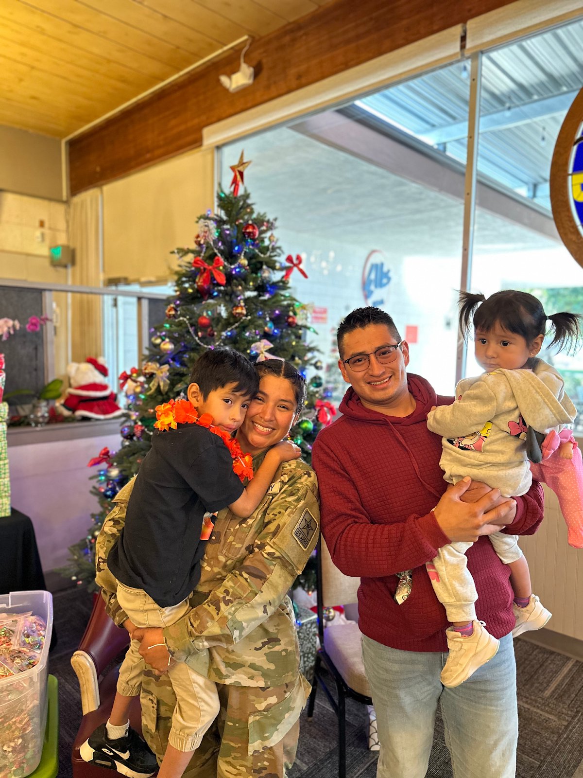 A Family Smiling Together Near a Christmas Tree.
