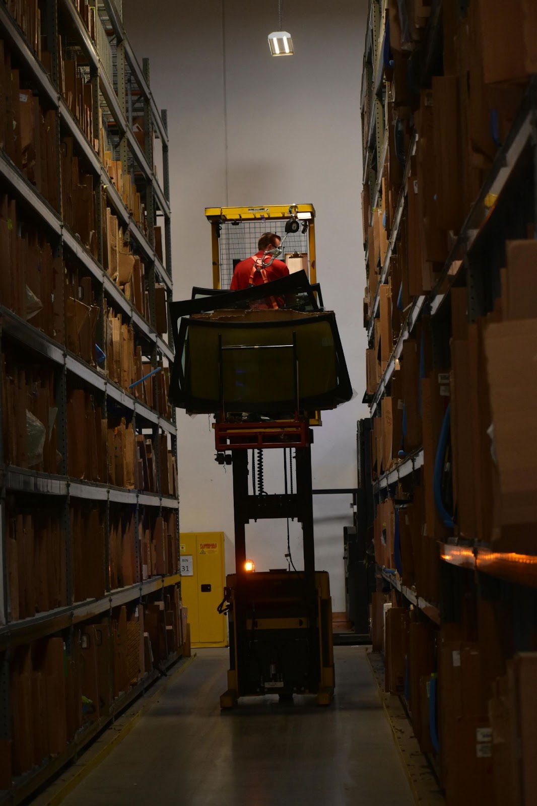 A forklift operator sitting in a forklift high off the ground